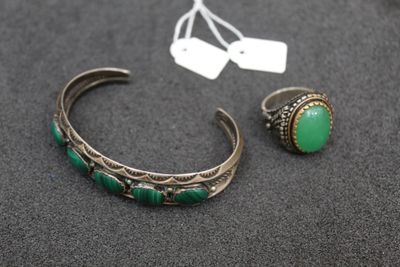 a close up of a bracelet and a ring on a table