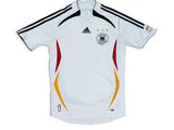 a white soccer jersey with a black and yellow stripe on the chest