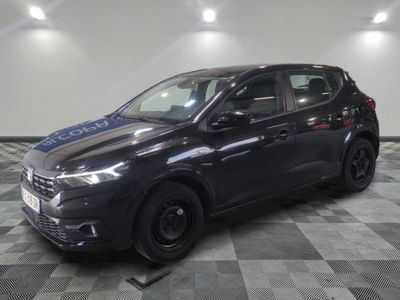 une voiture noire est garée dans une pièce au sol en damier