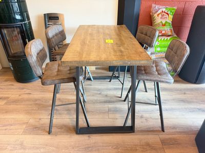 une table en bois entourée de quatre chaises dans une pièce
