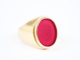 une image d'une bague en or avec une pierre rouge