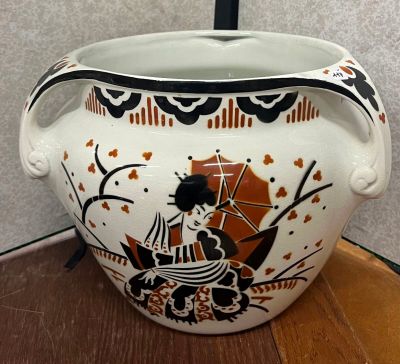un vase blanc orné d'un motif noir et orange