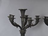 two metal candelabs on a table with a white background