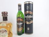 trois bouteilles d'alcool sont posées les unes à côté des autres sur une surface blanche