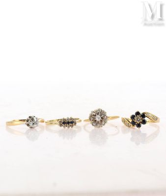 three gold rings with black and white diamonds on a white surface