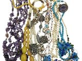 a lot of necklaces and bracelets on a white background