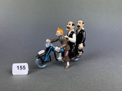 a figurine of a man and woman riding a motorcycle