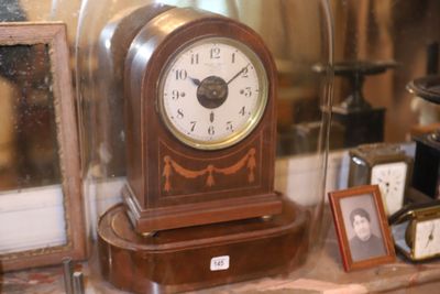 une horloge posée sur une étagère dans une vitrine