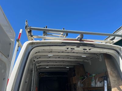 une camionnette blanche avec une échelle à l'arrière