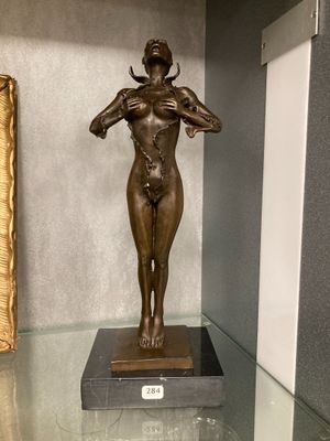 a bronze statue of a woman standing on a glass table