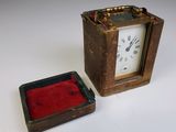 a small clock that is sitting next to a small box