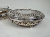 two silver plated dishes with a glass bowl on top of them