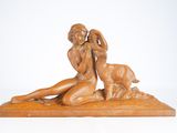 statue représentant une femme et un chien, posée sur un socle en bois