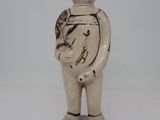 une petite statue représentant un homme avec un oiseau sur l'épaule