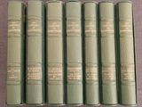 six livres verts sont alignés sur une table