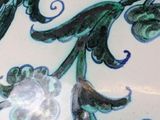 a close up of a plate with a flower design on it