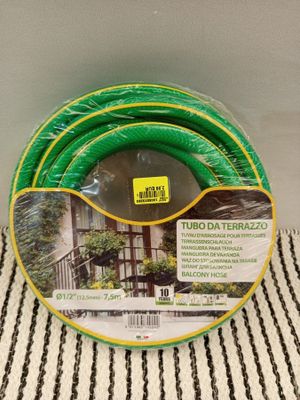 a green hose sitting on top of a white and black striped towel