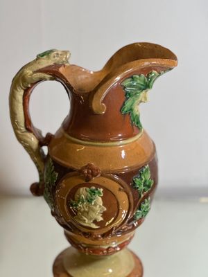 a brown and green vase sitting on a glass table