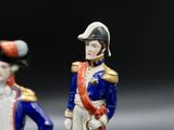 two figurines of a man and a woman dressed in uniforms