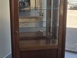 une vieille vitrine en bois avec des portes vitrées, dans une pièce