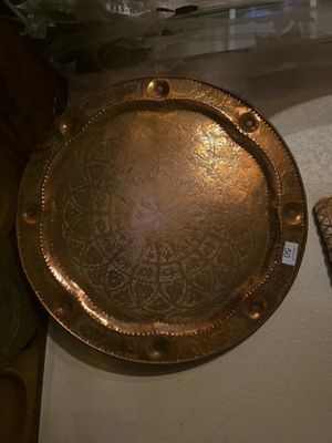 une assiette en or posée sur une table, à côté d'une télécommande