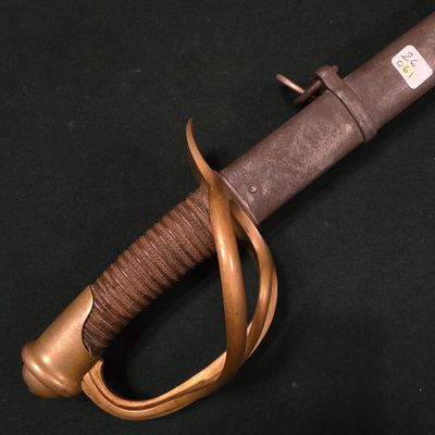 un gros plan d'une épée à poignée en bois sur fond noir