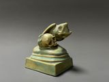 a close up of a statue of a bird with a skull on it