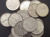 un tas de pièces d'argent posées sur une table, avec une étiquette indiquant le prix