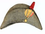 an old military hat with a red feather on it
