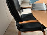a wooden table with a black chair and a laptop on it