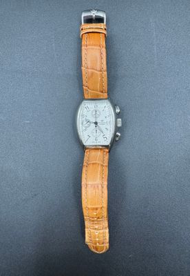 une image représentant une montre avec un bracelet marron sur un fond noir