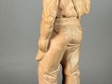 carved wooden statue of a man in a military uniform holding a baseball bat