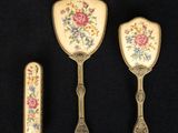 trois couverts ornés de motifs floraux sur un fond noir