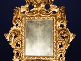 un cadre doré richement décoré, avec un miroir sur fond bleu