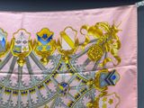 an image of a pink silk scarf with gold and blue designs on it