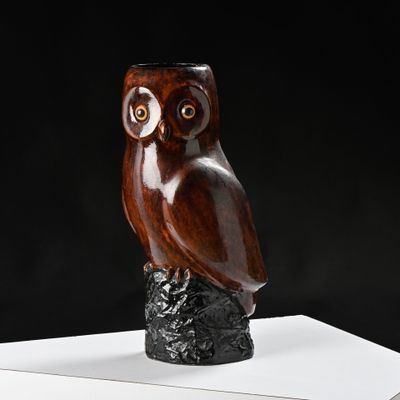 un hibou en bois perché sur un morceau de bois