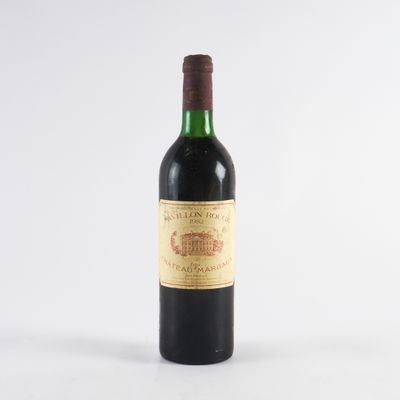 une vieille bouteille de vin posée sur une table blanche