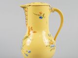 a small yellow vase with a floral design on it