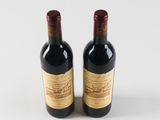 two bottles of wine sitting next to each other on a white surface