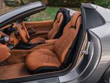 the interior of a silver sports car with brown leather seats