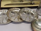 a silver plate with a knife, spoon, and other silverware