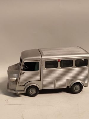 un petit bus en plastique posé sur une surface blanche