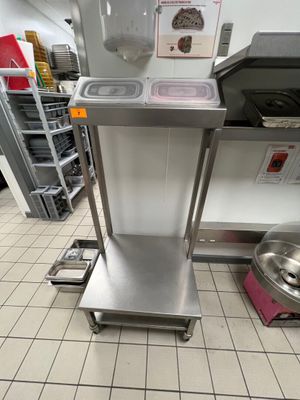 un chariot de cuisine en acier inoxydable surmonté d'un saladier