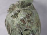 a statue of a lion head on a white surface