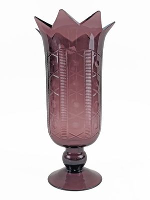 purple glass vase sitting on top of a wooden stand