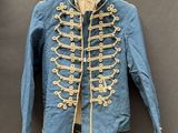une veste militaire bleue avec des boutons dorés, suspendue à un cintre