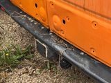 a rusted orange van parked on the side of the road