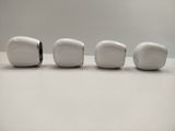 three white toothbrushes lined up on a white surface
