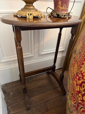 une petite table sur laquelle est posée une lampe, à côté d'une chaise