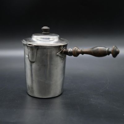 a silver pot with a wooden handle on a table